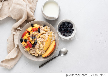 Oatmeal porridge with peach, raisins, cashews Oatmeal porridge with peach, raisins, cashews 71401953