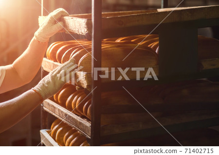 Seller puts bread on the shelf. 71402715