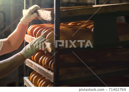 Seller puts bread on the shelf. 71402769