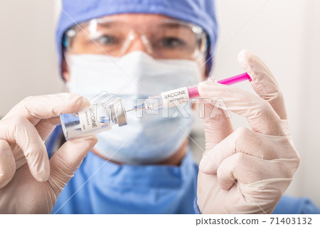 A medical worker putting SARS-CoV-2 vaccine against the coronavirus into an injection A medical worker putting SARS-CoV-2 vaccine against the coronavirus into an injection 71403132