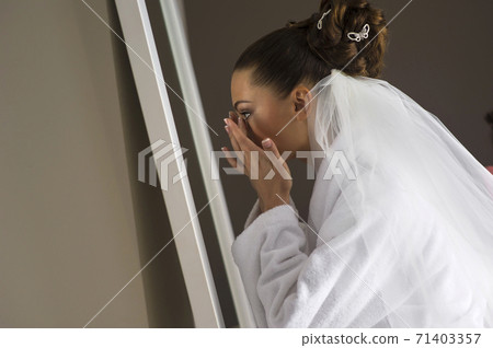 The beautiful bride is preparing for the ceremony in front of th 71403357