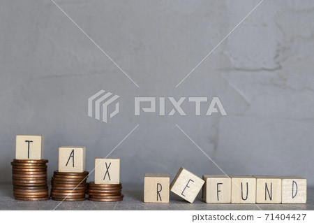 Tax refund text with wooden cubes on concrete modern background texture and stacking coins Tax refund text with wooden cubes on concrete modern background texture and stacking coins 71404427