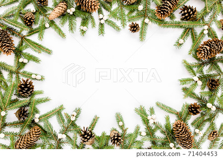 Frame made of Christmas composition with fir branches, pine cones on white background. Flat lay, top view holiday decoration concept. 71404453