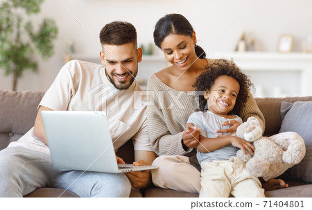 Diverse family using laptop on sofa together 71404801
