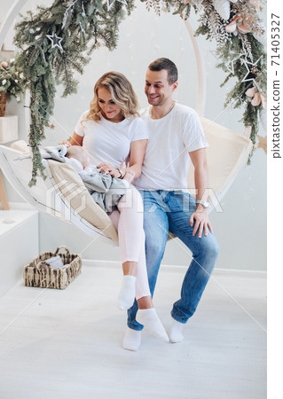Cheerful parents with baby on xmas swing. Portrait 71405327