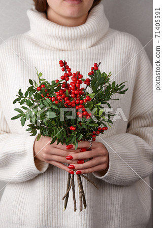 Woman holding Christmas red holly berries Woman holding Christmas red holly berries 71405591