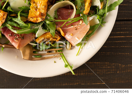 Salad with arugula, pumpkin, prosciutto and parmesan Salad with arugula, pumpkin, prosciutto and parmesan 71406046