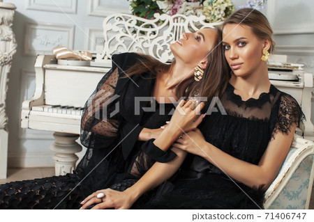 two young pretty lady in black lace fashion style dress posing in rich interior of royal hotel room, luxury lifestyle people concept two young pretty lady in black lace fashion style dress posing in rich interior of royal hotel room, luxury lifestyle people concept 71406747