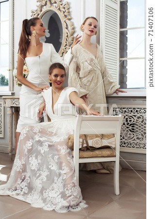 three young pretty lady in white lace fashion style dress posing in rich interior of royal hotel room, luxury lifestyle people concept, bride on wedding day three young pretty lady in white lace fashion style dress posing in rich interior of royal hotel room, luxury lifestyle people concept, bride on wedding day 71407106
