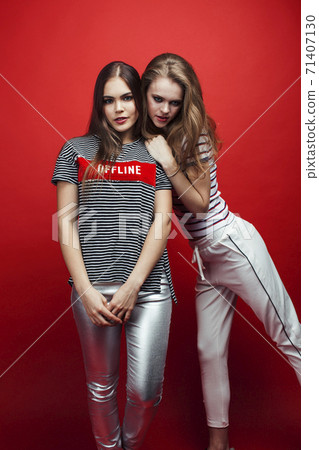 two best friends teenage girls together having fun, posing emotional on red background, lifestyle people concept 71407130