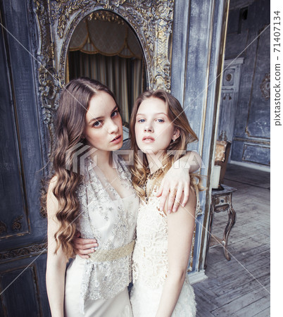 two pretty twin sister blond curly hairstyle girl in luxury house interior together, rich young people concept two pretty twin sister blond curly hairstyle girl in luxury house interior together, rich young people concept 71407134