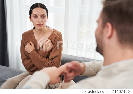 Woman telling something nonverbal to her husband Woman telling something nonverbal to her husband 71407400