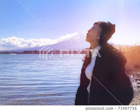 woman tourists are traveling feel happy with Mt Fuji in the morning on the lake kawaguchiko, Japan 71407738