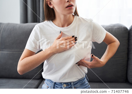 Woman cheking her breast on the cancer symptom 71407746