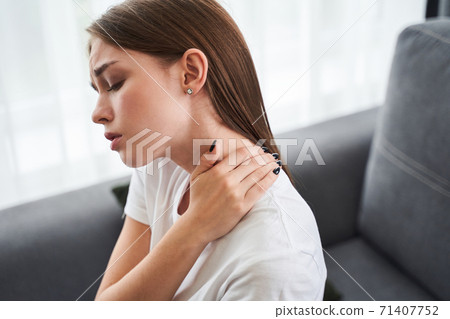 Woman massaging stiff sore neck Woman massaging stiff sore neck 71407752
