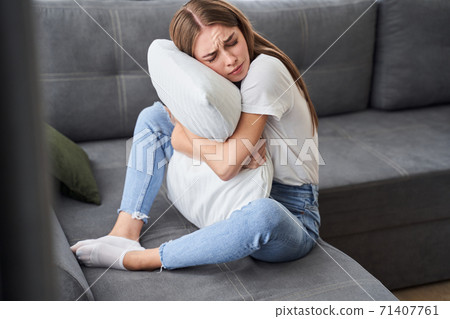 Sad girl holding pillow Sad girl holding pillow 71407761