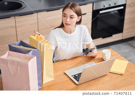 Woman looking at her purchases Woman looking at her purchases 71407811