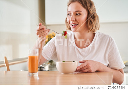 Woman tasting fresh salad Woman tasting fresh salad 71408364