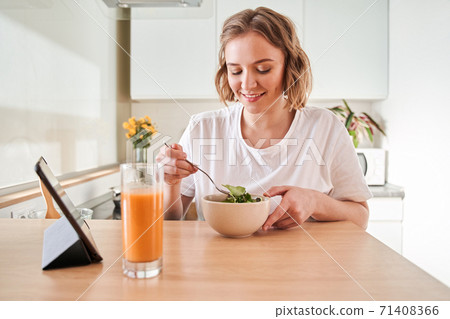Happy woman eating salad 71408366