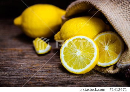 Group of fresh yellow lemon fruit on wood background with burlap 71412671