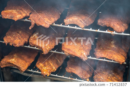 smoke rising around a slow cooked beef brisket on a smoker barbecue grilling concept 71412837