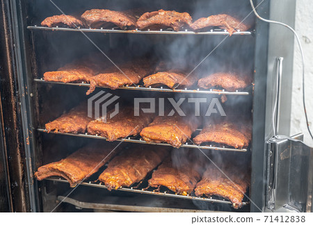 smoke rising around a slow cooked beef brisket on a smoker barbecue grilling concept 71412838