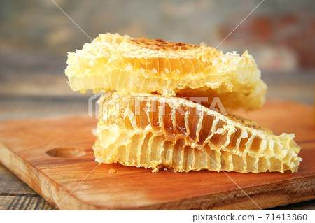 Honeycomb on an old wooden background. Honeycomb on an old wooden background. 71413860