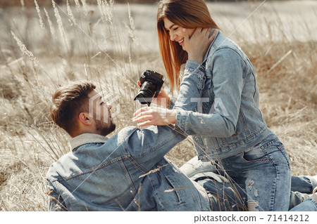 Cute couple in a jeans clothes in a spring field 71414212