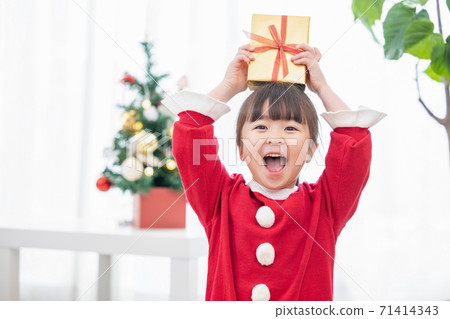 A girl who is happy to receive a Christmas present 71414343