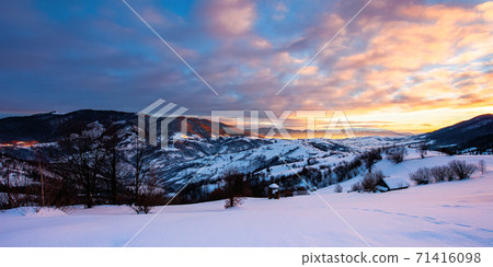 winter mountain landscape at sunrise. trees and fields on snow covered hills. ridge in the distance beneath a dramatic sky with clouds. beautiful carpathian countryside winter mountain landscape at sunrise. trees and fields on snow covered hills. ridge in the distance beneath a dramatic sky with clouds. beautiful carpathian countryside 71416098