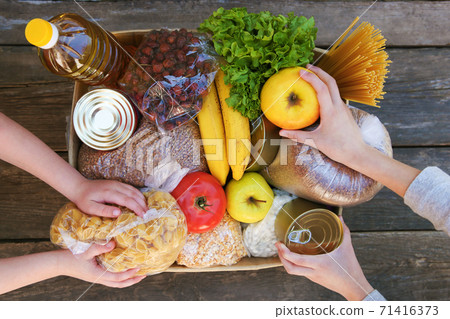 Donation box with food on old wooden background. Top view. Donation box with food on old wooden background. Top view. 71416373