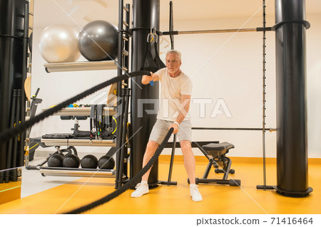 A man in sportswear doing exercises in gym 71416464