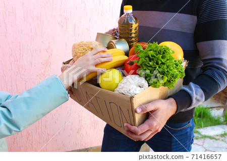Man holds donation box with food. 71416657