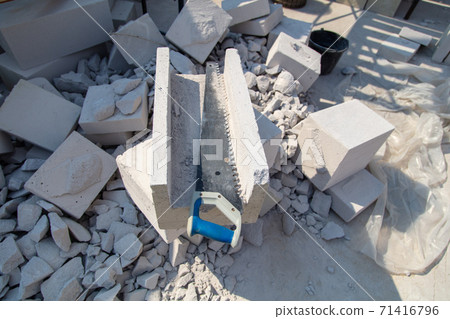 A worker cuts aerated concrete bricks with a saw. 71416796