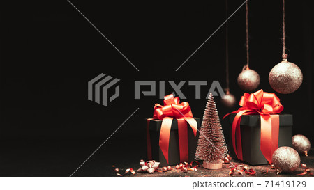 gift boxes and christmas tree with red ribbon, balls and glitter gold confetti, star with copy space 71419129