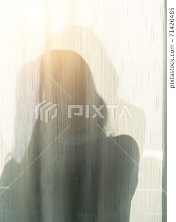 A woman shadow behind a white curtain 71420485