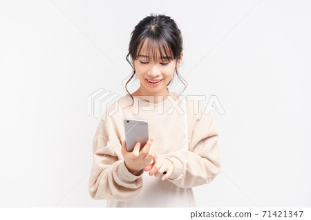 一個操作智能手機的年輕女子 一個操作智能手機的年輕女子 71421347
