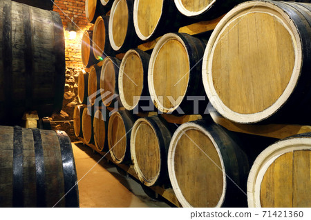 Rows of alcohol barrels in stock. Distillery. Cognac, whiskey, wine, brandy. Alcohol in barrels 71421360