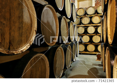 Rows of alcohol barrels in stock. Distillery. Cognac, whiskey, wine, brandy. Alcohol in barrels 71421365