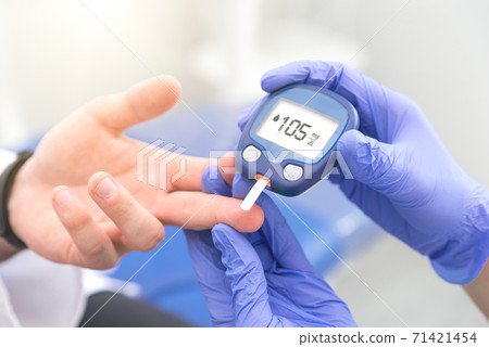 Doctor making blood sugar level test in clinic Doctor making blood sugar level test in clinic 71421454