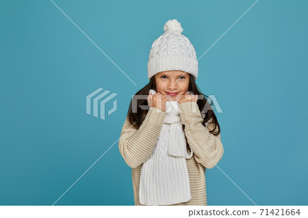 cheerful child girl in white winter knitted hat 71421664