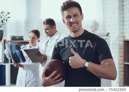 Man holding ball and showing super gesture.  71422884