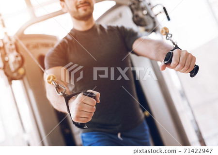 Man doing strength exercises on modern simulator. Man doing strength exercises on modern simulator. 71422947