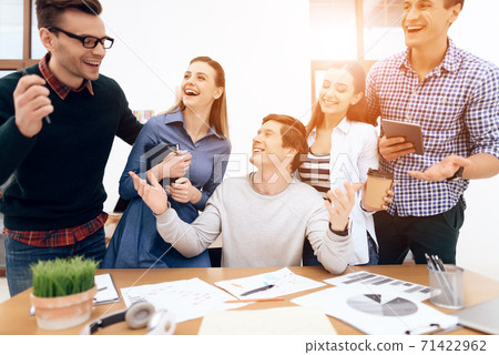 People stand and talk with a man at the table. People stand and talk with a man at the table. 71422962