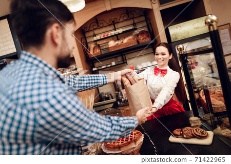 Smiling Girl Giving Package with Bread to Man. Smiling Girl Giving Package with Bread to Man. 71422965