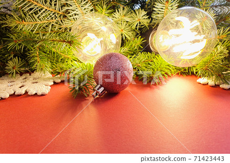 Christmas decorations. Fir, stars, balls and magic lights on red background . Atmospheric frame, place for text or your product. Christmas flatlay style 71423443