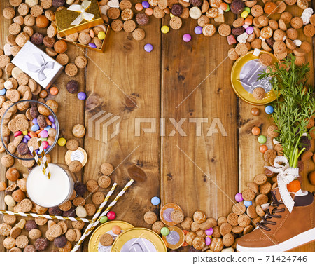 Sinterklaas. Dutch holiday postcard. Wooden background with childrens shoe with carrots for Santa's Sinterklaas. Dutch holiday postcard. Wooden background with childrens shoe with carrots for Santa's 71424746