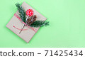 Christmas gift box wrapped in brown craft paper with corn, fir-tree and candy on green background.New Year and Christmas concept. 71425434