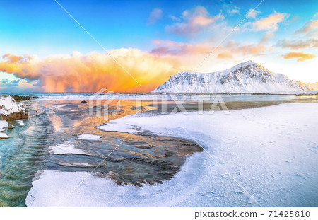 Outstanding  winter scenery on Skagsanden beach with illuminated clouds during sunrise. 71425810