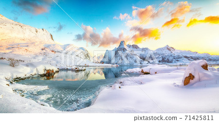 Fantastic frozen Flakstadpollen and Boosen fjords and reflection in water during sunrise  71425811
